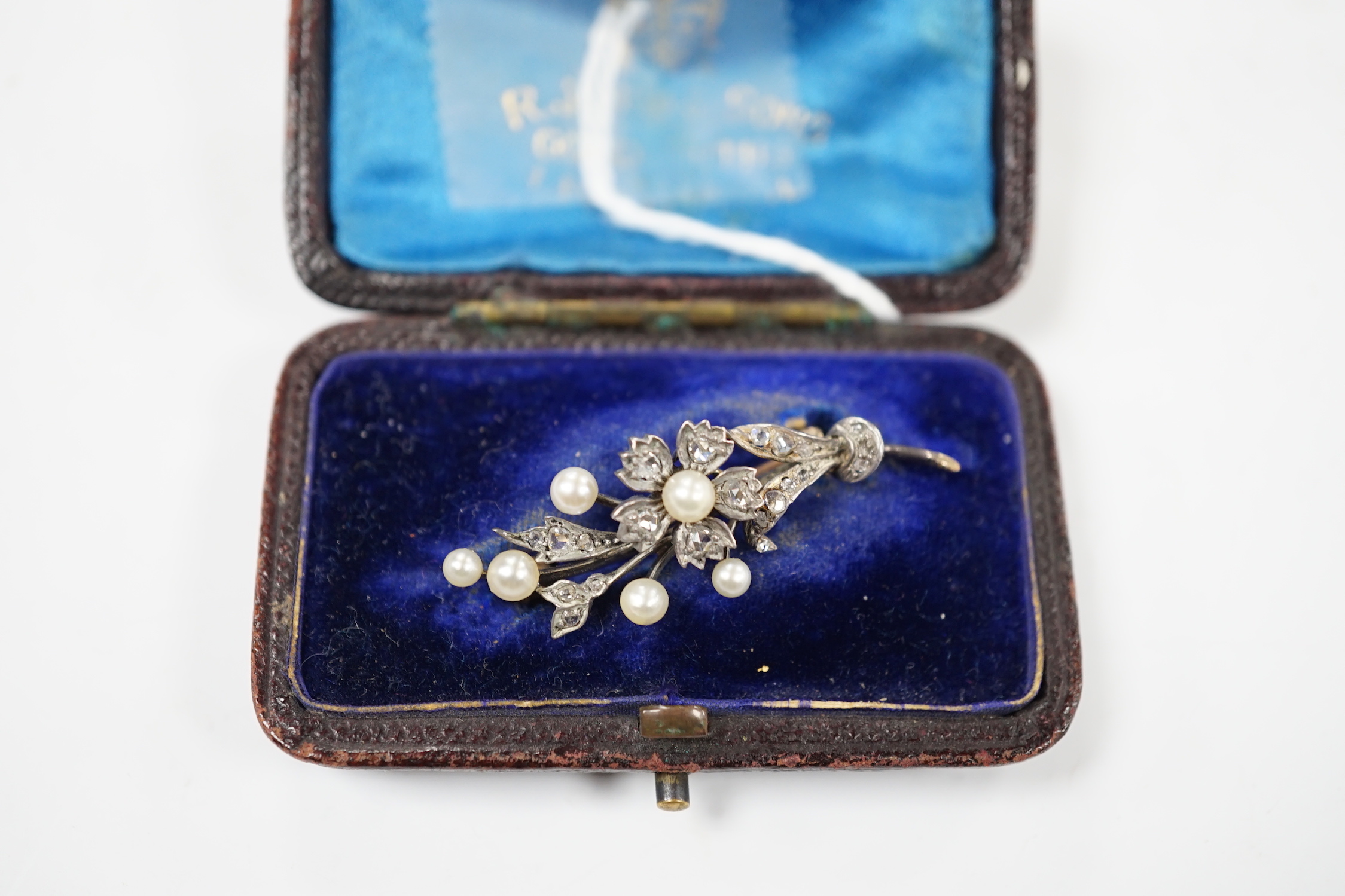 A cased Victorian yellow metal, seed pearl and rose cut diamond set foliate spray brooch, 39mm, gross weight 4.4 grams.